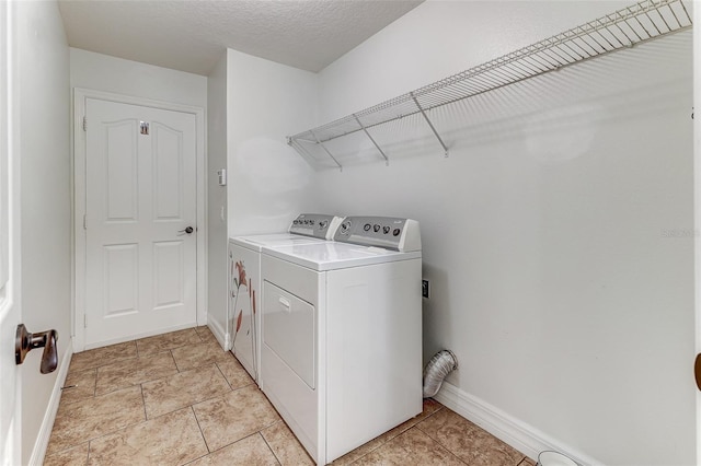 washroom with washer and dryer and a textured ceiling