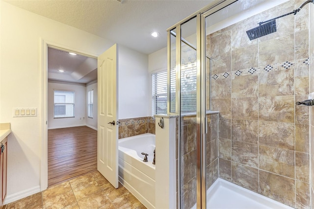 bathroom featuring separate shower and tub, vanity, and a textured ceiling