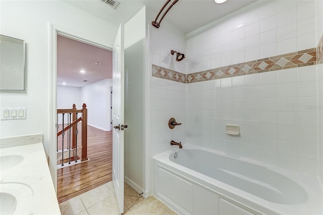 bathroom with tile patterned floors, tiled shower / bath combo, and vanity