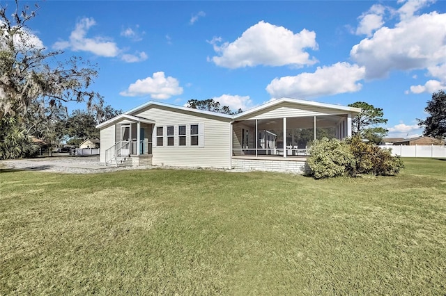 back of house featuring a yard and a sunroom