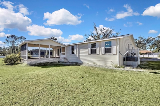 rear view of house with a sunroom and a yard