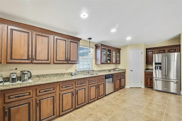 kitchen with light stone countertops, appliances with stainless steel finishes, sink, decorative light fixtures, and light tile patterned flooring