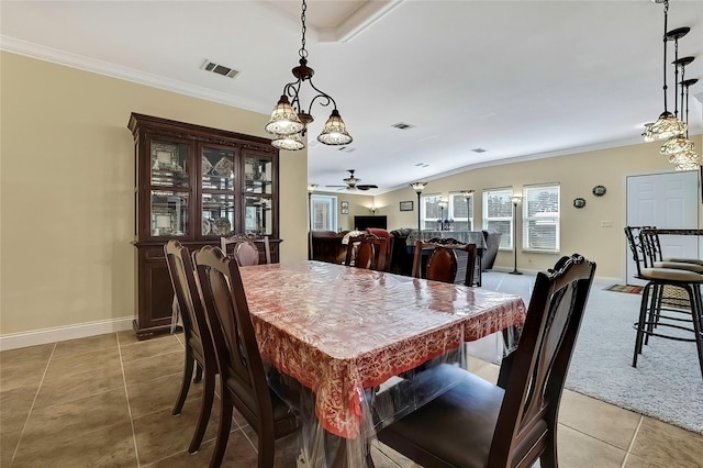 tiled dining area featuring ceiling fan with notable chandelier, vaulted ceiling, and crown molding