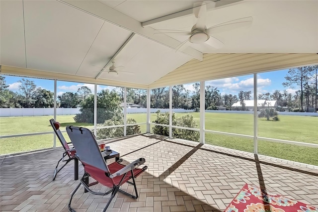 unfurnished sunroom featuring ceiling fan and vaulted ceiling