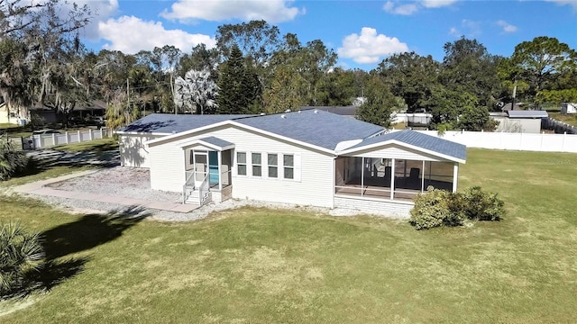 back of house with a lawn and a sunroom