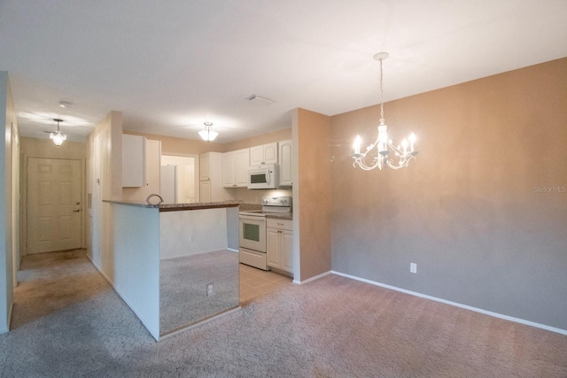 kitchen featuring white cabinetry, a notable chandelier, kitchen peninsula, light colored carpet, and white appliances