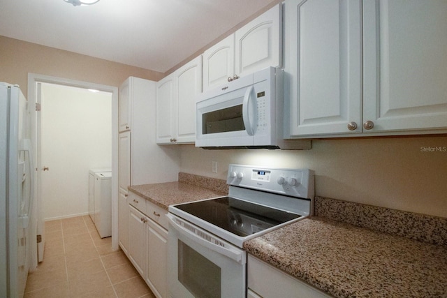 kitchen featuring white cabinets, washer / dryer, white appliances, and light tile patterned floors