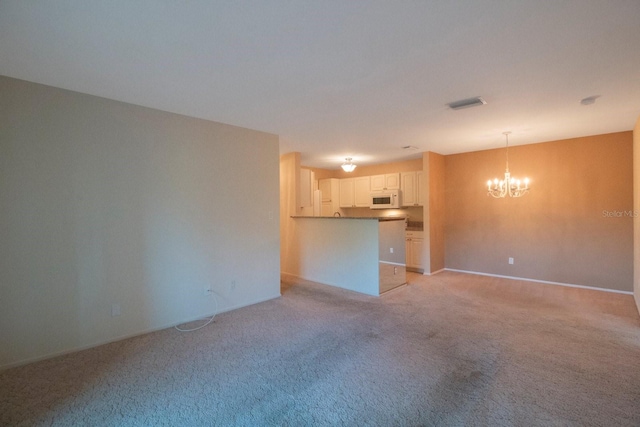 unfurnished living room featuring a chandelier and light colored carpet