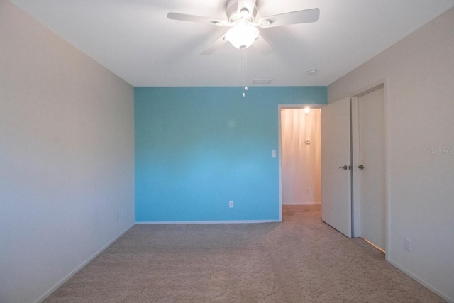 spare room with light carpet and ceiling fan