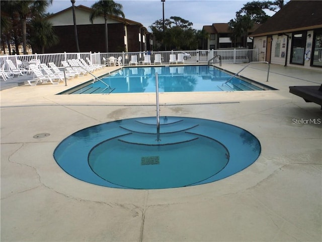 view of pool with a patio area and a hot tub