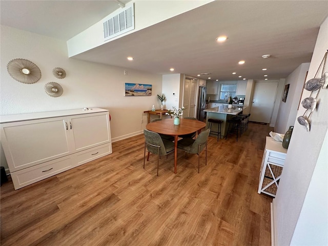 dining space with light hardwood / wood-style flooring