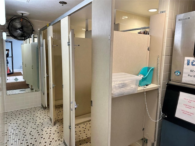 bathroom with tile patterned flooring and tile walls