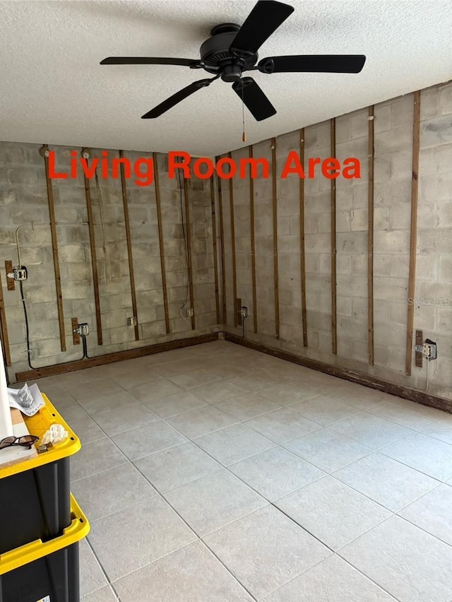 259 Medallion Blvd Unit B, Madeira Beach, FL 33708 - basement featuring a textured ceiling, a ceiling fan, concrete block wall, and tile patterned floors