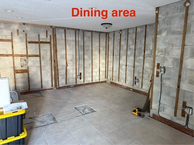 basement with tile patterned flooring and a textured ceiling