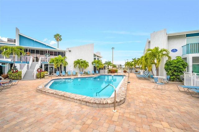 view of swimming pool featuring cooling unit and a patio