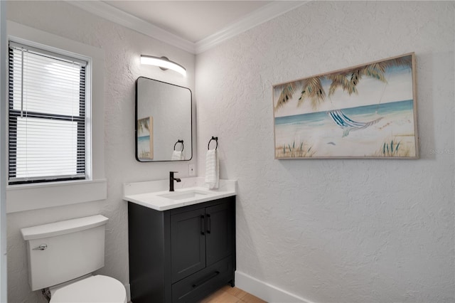 bathroom with toilet, vanity, and ornamental molding