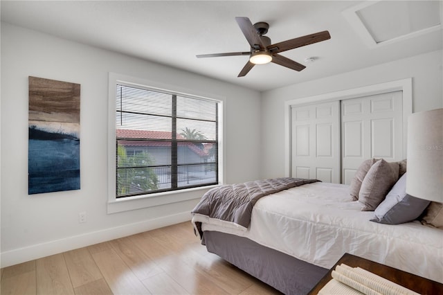 bedroom featuring ceiling fan, light hardwood / wood-style floors, and a closet