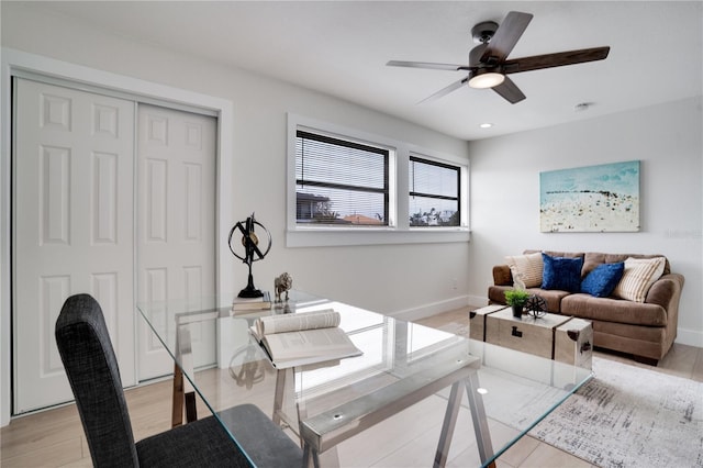 office with light wood-type flooring and ceiling fan