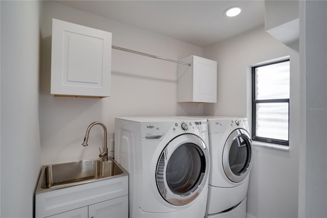 laundry area featuring cabinets, washer and clothes dryer, and sink