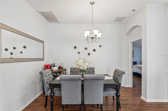 dining area featuring a chandelier and dark wood-type flooring