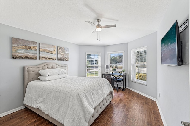 bedroom with a textured ceiling, ceiling fan, and dark wood-type flooring