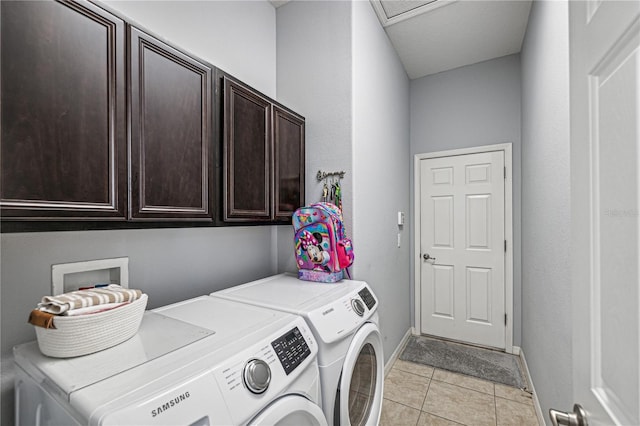 clothes washing area with cabinets, independent washer and dryer, and light tile patterned floors