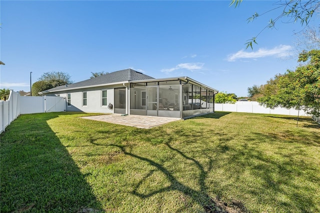 rear view of property featuring a sunroom, a patio area, and a yard