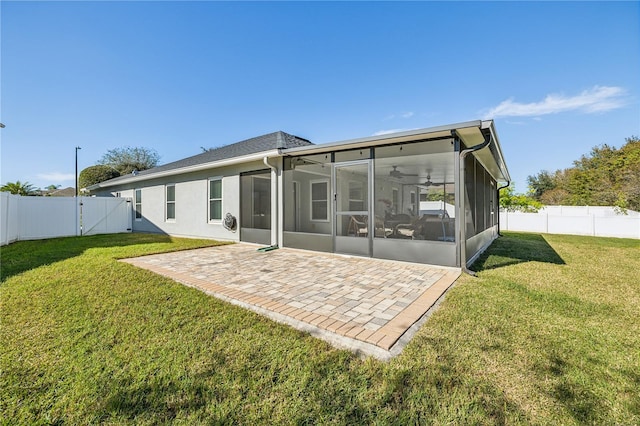 rear view of property with a sunroom, a patio area, and a lawn