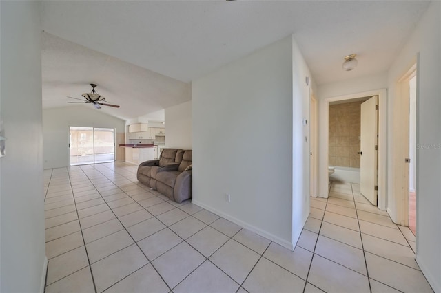 hallway with light tile patterned flooring and lofted ceiling