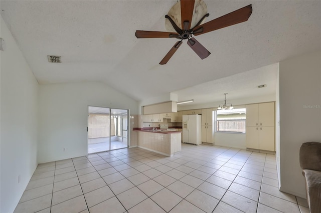 unfurnished living room featuring a textured ceiling, ceiling fan, light tile patterned floors, and vaulted ceiling