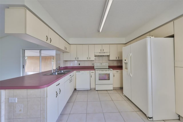 kitchen featuring a textured ceiling, white appliances, tasteful backsplash, and light tile patterned floors