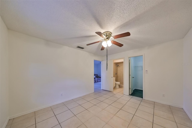 tiled empty room featuring a textured ceiling and ceiling fan