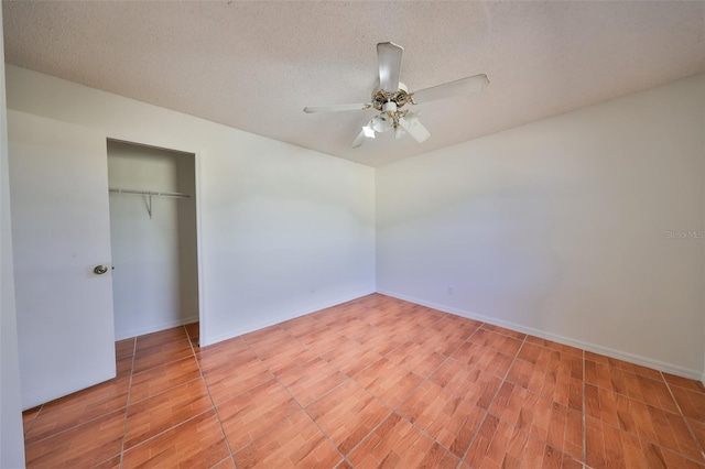 unfurnished bedroom with ceiling fan, wood-type flooring, a textured ceiling, and a closet