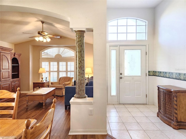 foyer with ceiling fan, ornate columns, light tile patterned floors, and lofted ceiling