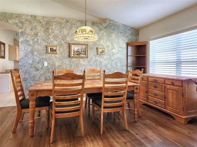 dining room with hardwood / wood-style floors and lofted ceiling