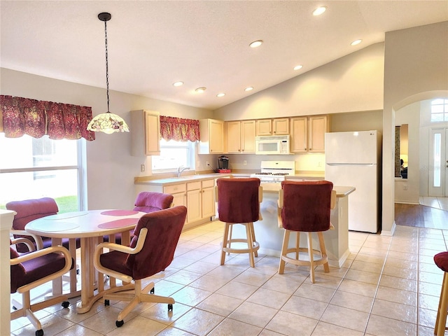 kitchen with hanging light fixtures, white appliances, sink, and light tile patterned floors