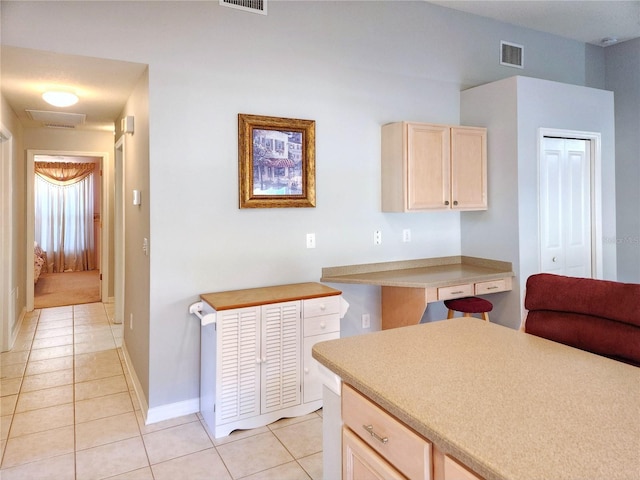 kitchen with light brown cabinets and light tile patterned floors