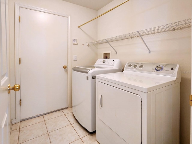 washroom featuring light tile patterned flooring and washing machine and dryer