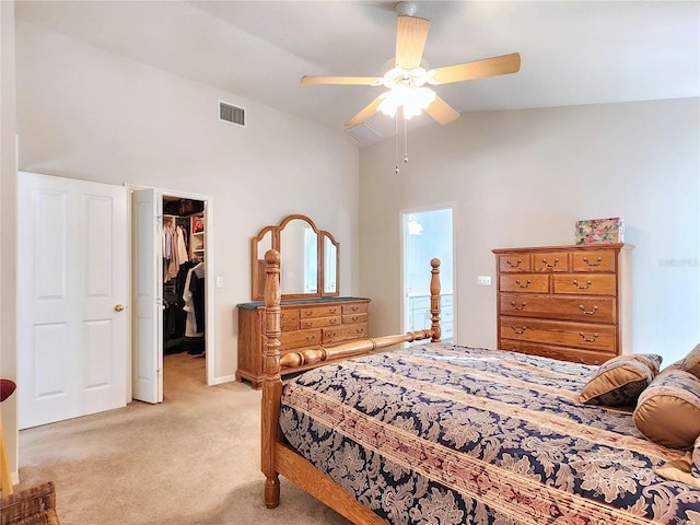 carpeted bedroom featuring ceiling fan, lofted ceiling, a walk in closet, and a closet