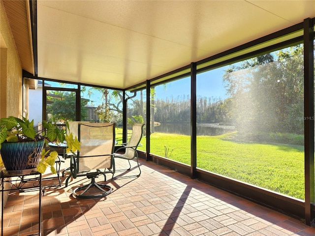 unfurnished sunroom featuring a water view and a wealth of natural light