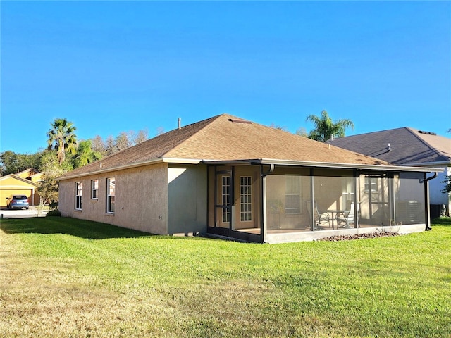 back of house with a sunroom and a lawn