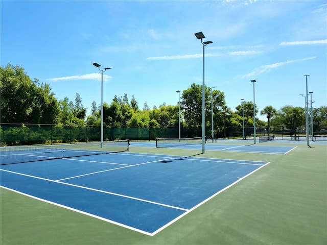 view of tennis court featuring basketball hoop