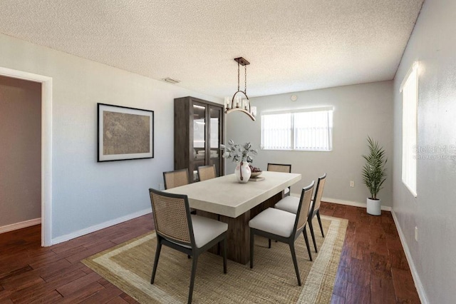 dining area with dark hardwood / wood-style floors and a textured ceiling