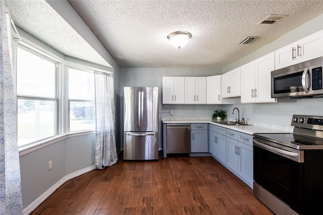 kitchen featuring sink, white cabinets, stainless steel appliances, and dark hardwood / wood-style floors