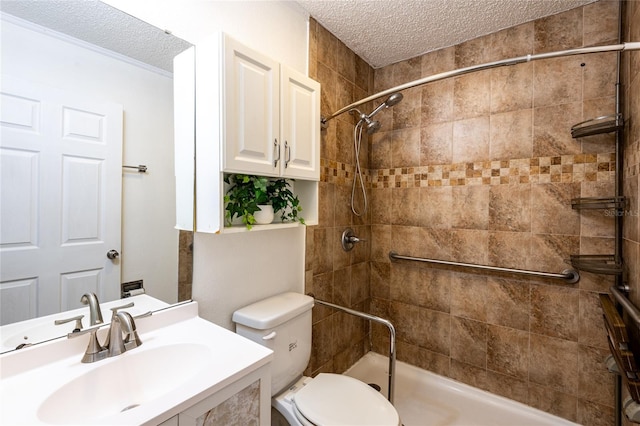 bathroom featuring toilet, a tile shower, a textured ceiling, and vanity