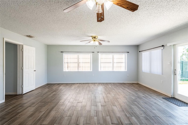 spare room featuring hardwood / wood-style floors, a textured ceiling, and a wealth of natural light