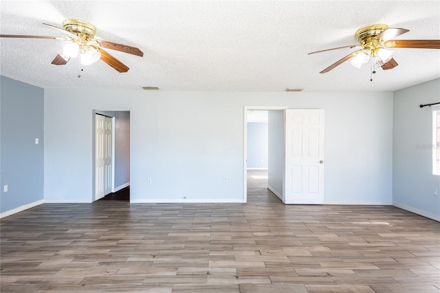 spare room with light hardwood / wood-style floors and a textured ceiling