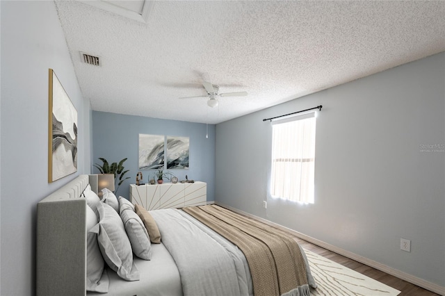 bedroom featuring ceiling fan, a textured ceiling, and hardwood / wood-style flooring