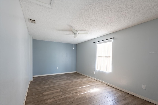 empty room with hardwood / wood-style flooring, ceiling fan, and a textured ceiling