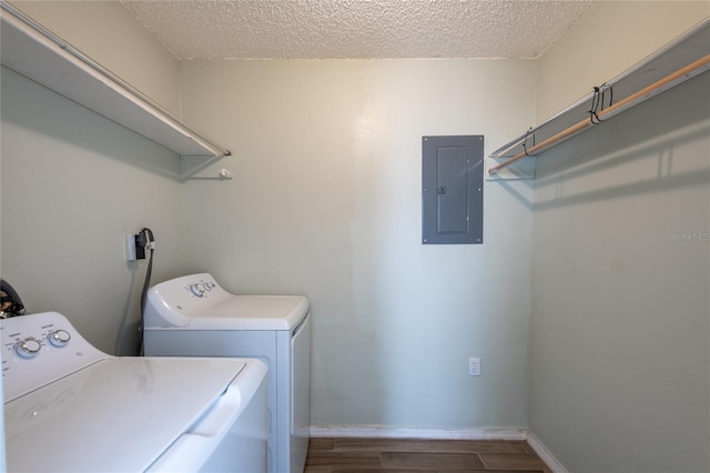 washroom featuring washer and clothes dryer, dark wood-type flooring, electric panel, and a textured ceiling